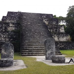 The east Pyramid of Complex Q at Tikal Guatemala. Structure is a flat top pyramid with steps leading to the top on the front. In front of the Pyramid are a series of upright stone tablets