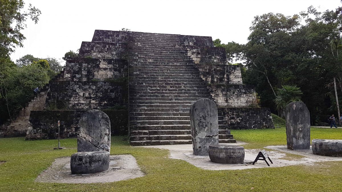 The east Pyramid of Complex Q at Tikal Guatemala. Structure is a flat top pyramid with steps leading to the top on the front. In front of the Pyramid are a series of upright stone tablets