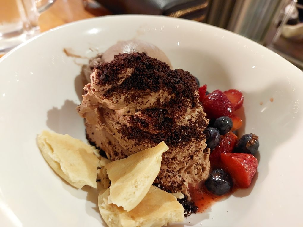 Pictured is the chocolate mousse dessert at The Anchorage, garnished with toffee pieces and fresh berries